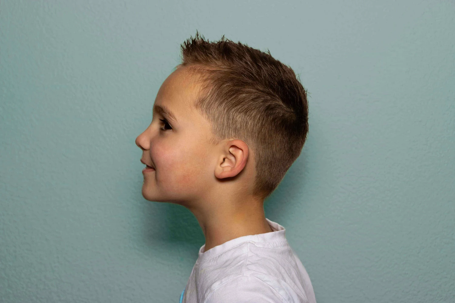 Ein Junge mit kurzen Haaren direkt nach dem frischen Haarschnitt